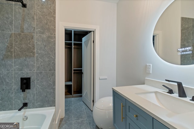 bathroom featuring tile patterned flooring, tiled shower / bath, and vanity