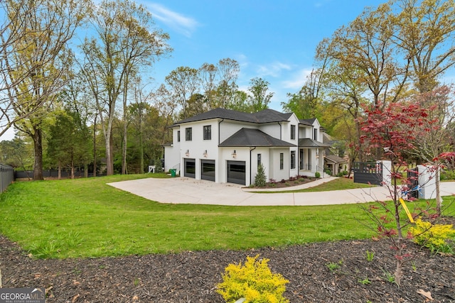 rear view of property with a garage and a lawn