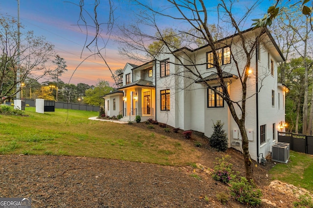 view of front of home featuring a lawn and central AC unit