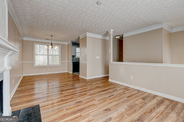 unfurnished living room with an inviting chandelier, crown molding, a high end fireplace, and light hardwood / wood-style floors