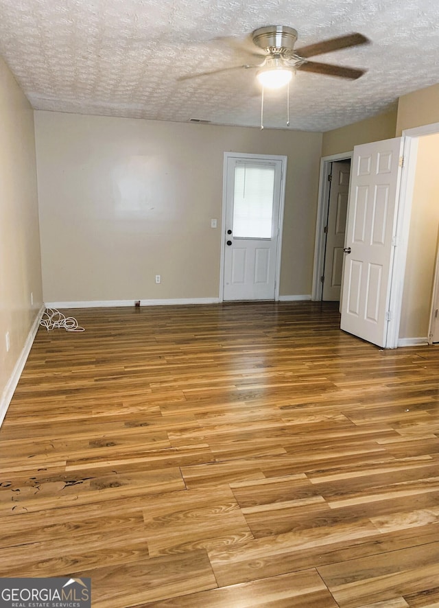 unfurnished room featuring ceiling fan, a textured ceiling, and light wood-type flooring