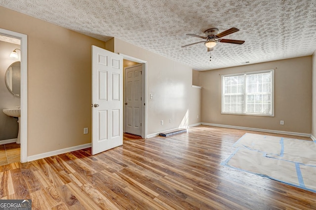 interior space with ceiling fan, a textured ceiling, and light wood-type flooring