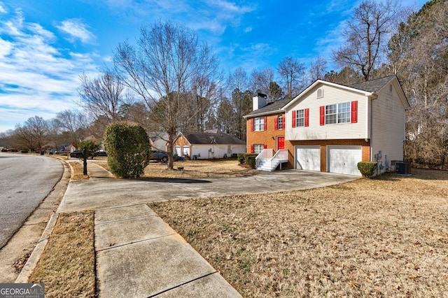 view of side of property featuring a garage and central air condition unit