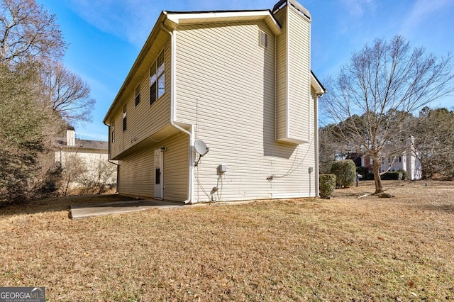 rear view of house featuring a patio area and a lawn