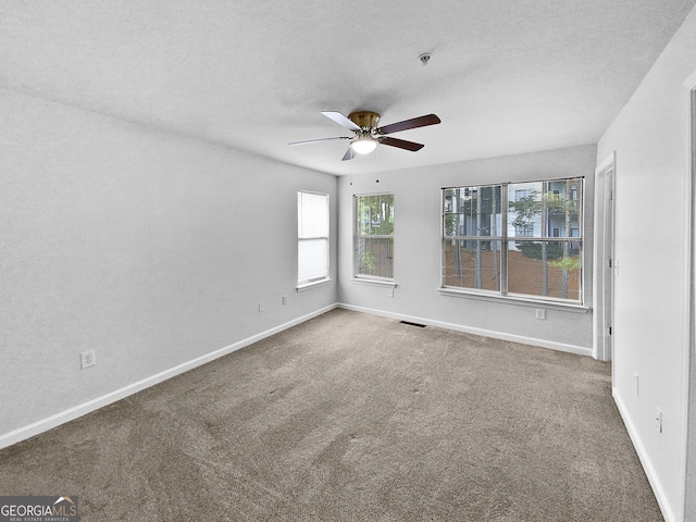 unfurnished room with a textured ceiling, ceiling fan, and carpet floors