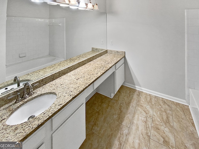 bathroom with vanity and a bath