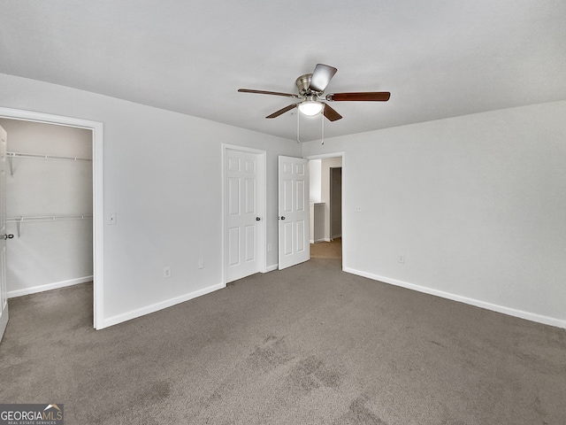 unfurnished bedroom featuring dark carpet and ceiling fan