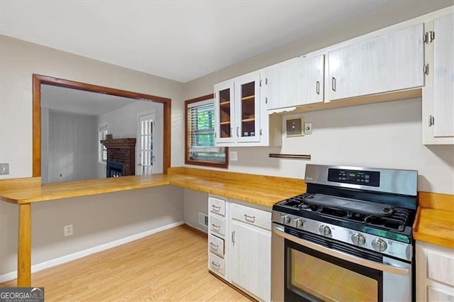 kitchen featuring white cabinetry, light hardwood / wood-style flooring, and stainless steel gas range oven