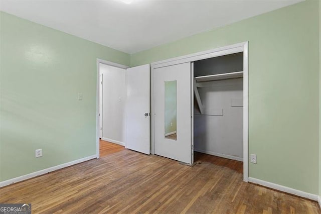 unfurnished bedroom featuring a closet and hardwood / wood-style flooring