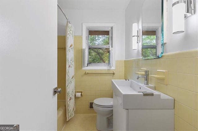 full bathroom with tile patterned flooring, vanity, toilet, and tile walls