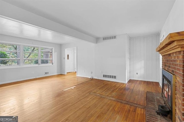 unfurnished living room featuring a fireplace and light hardwood / wood-style floors