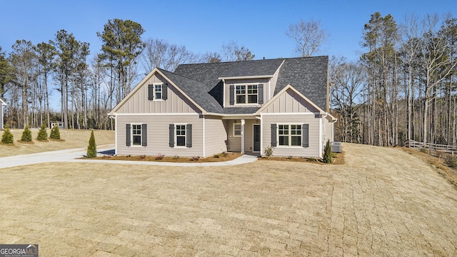 craftsman inspired home with central AC unit and a front lawn