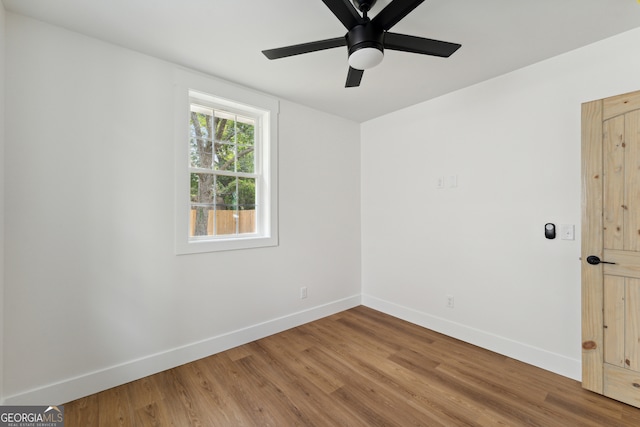 empty room with ceiling fan and hardwood / wood-style flooring