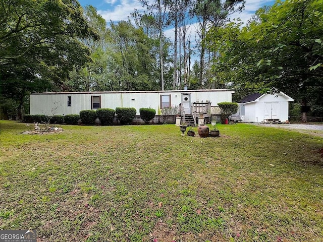 manufactured / mobile home with a storage shed and a front yard