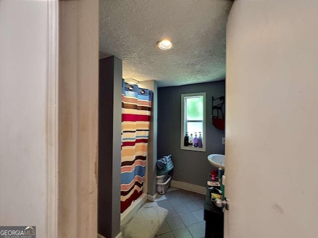 interior space featuring curtained shower and a textured ceiling