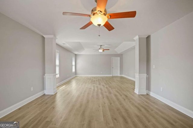 unfurnished living room featuring light wood-type flooring, ceiling fan, and decorative columns