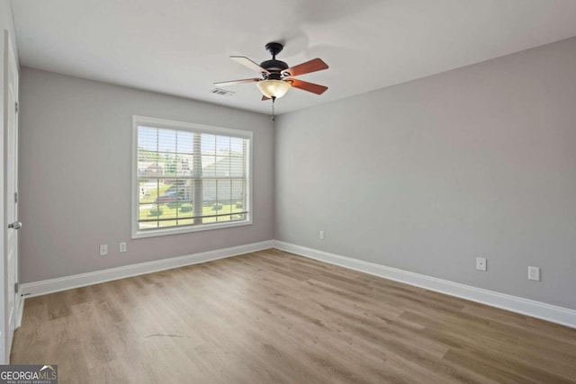 spare room with ceiling fan and light wood-type flooring