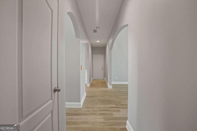 hallway with light hardwood / wood-style floors