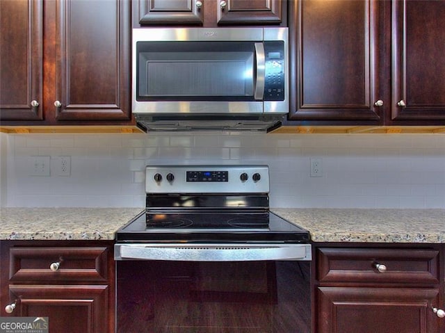 kitchen with backsplash, light stone countertops, and stainless steel appliances