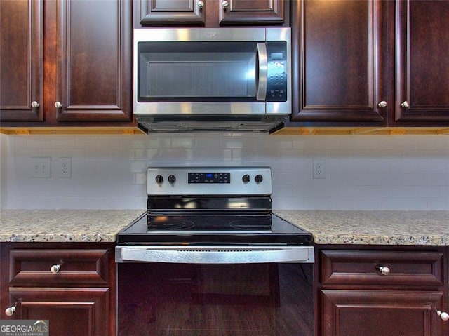 kitchen with appliances with stainless steel finishes, dark brown cabinetry, and backsplash