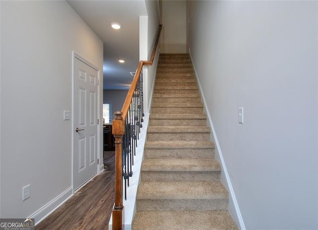 staircase featuring recessed lighting, baseboards, and wood finished floors