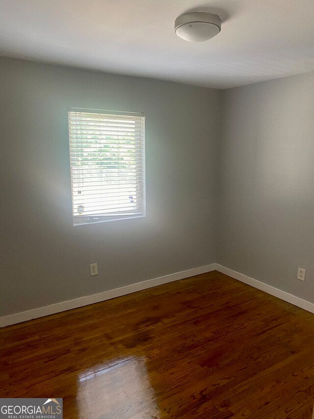 spare room with dark hardwood / wood-style flooring