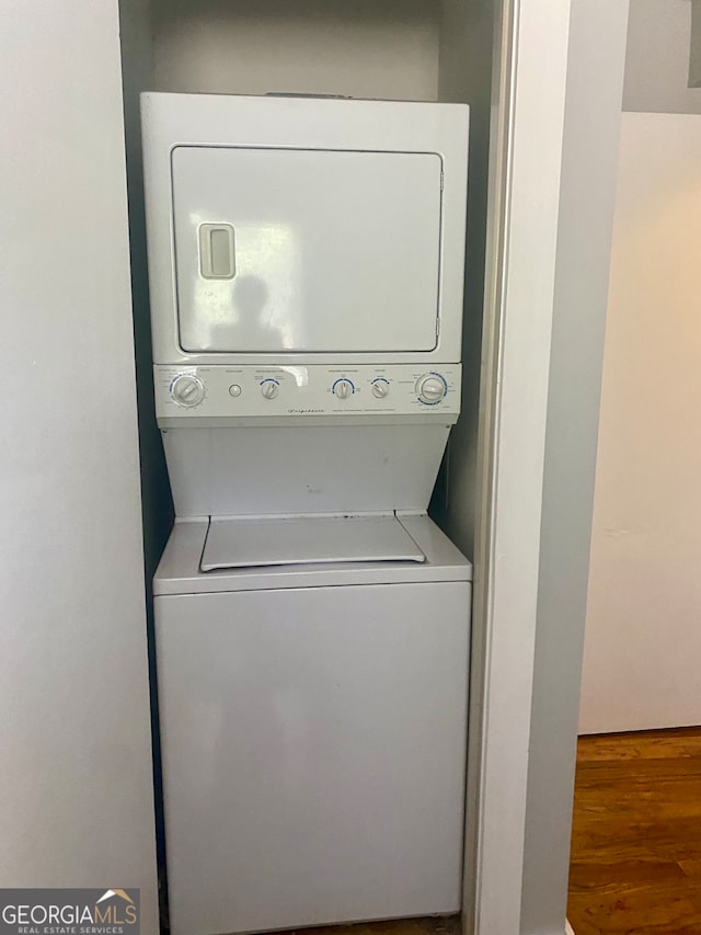 washroom featuring stacked washer and dryer and hardwood / wood-style flooring