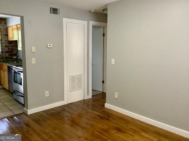 interior space featuring dark hardwood / wood-style floors, stainless steel range, and sink