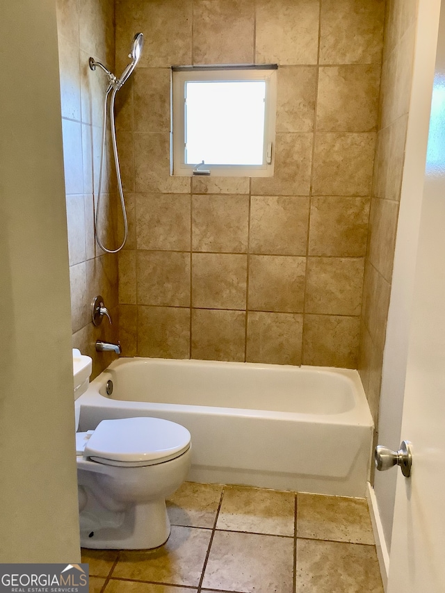 bathroom featuring tiled shower / bath, toilet, and tile patterned flooring