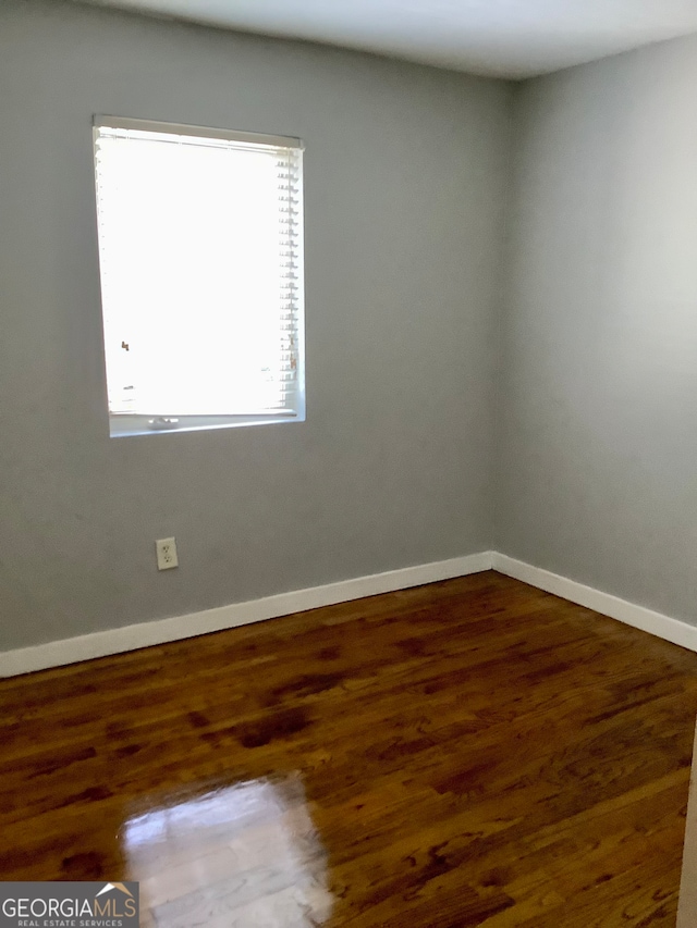 spare room with dark hardwood / wood-style flooring