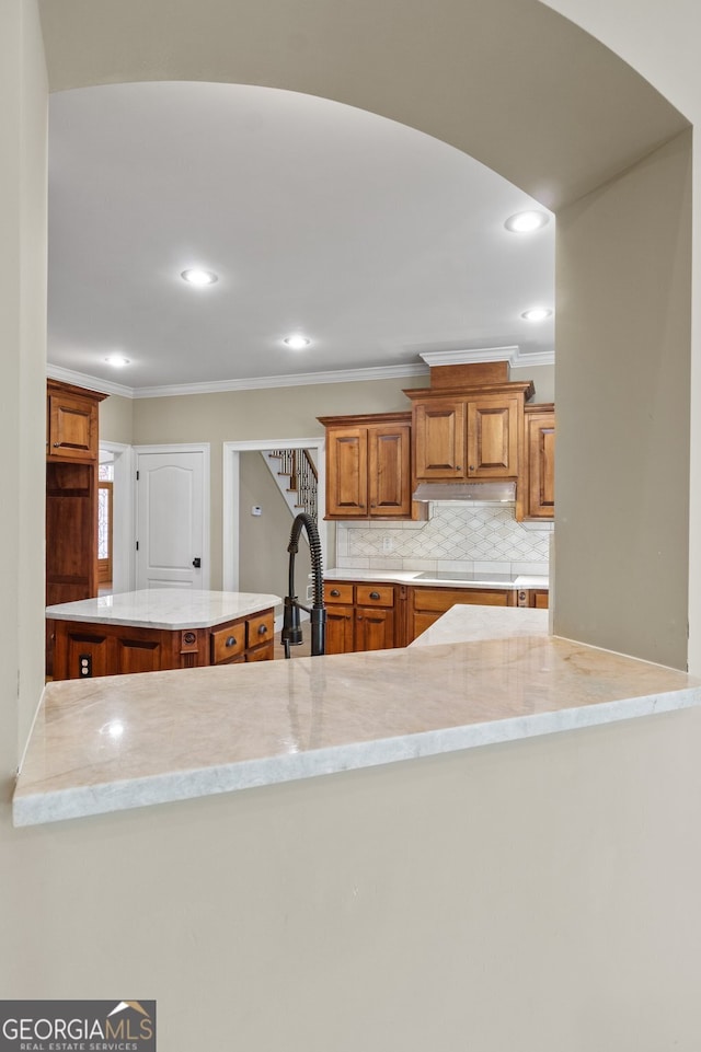 kitchen with cooktop, tasteful backsplash, kitchen peninsula, ornamental molding, and sink