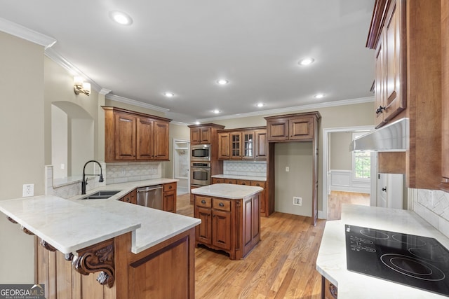 kitchen featuring a breakfast bar area, light hardwood / wood-style floors, kitchen peninsula, sink, and stainless steel appliances