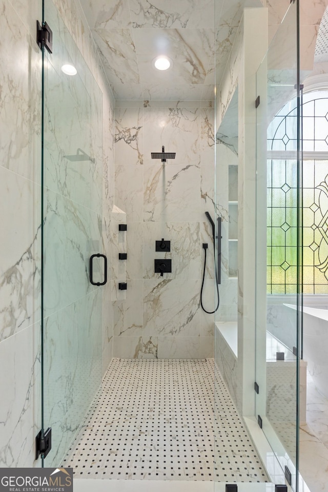 bathroom featuring a shower with door and plenty of natural light