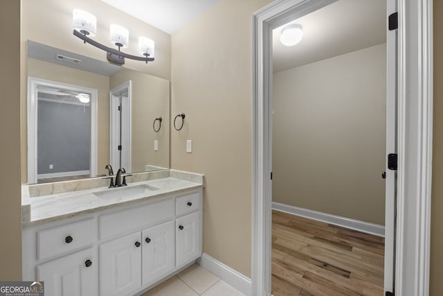 bathroom with wood-type flooring, ceiling fan, and vanity