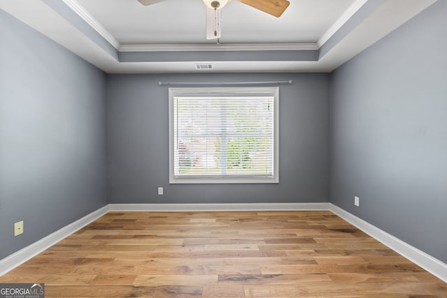 empty room with light wood-type flooring, ceiling fan, and ornamental molding