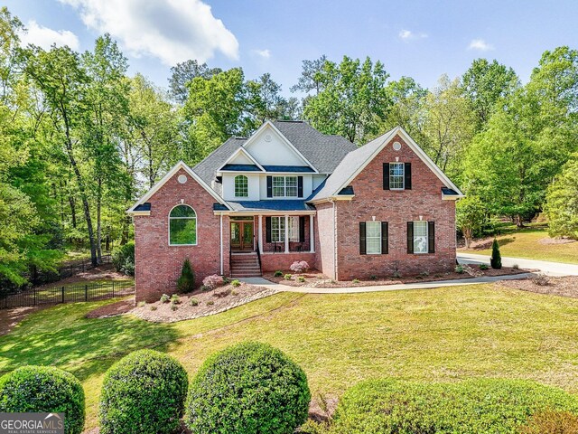 front of property featuring a front lawn and covered porch