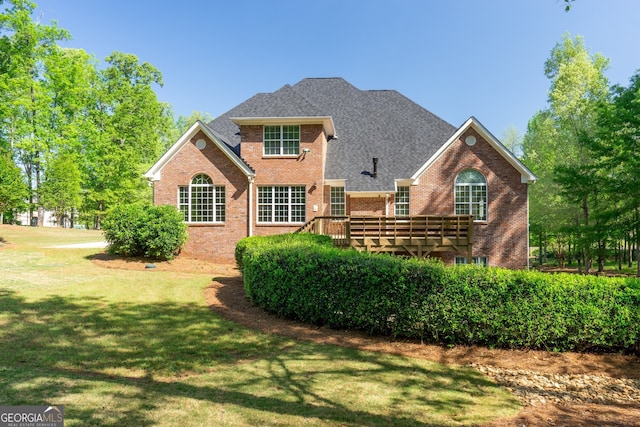 view of front facade featuring a wooden deck and a front lawn