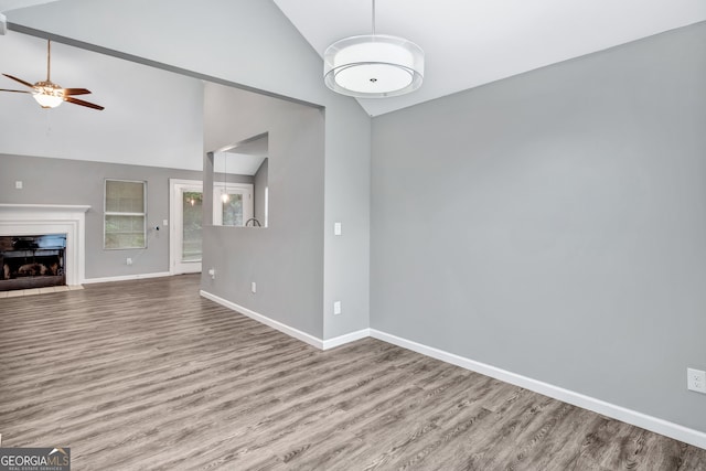 unfurnished living room with high vaulted ceiling, hardwood / wood-style flooring, and ceiling fan