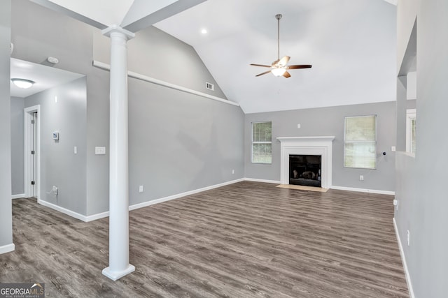 unfurnished living room with high vaulted ceiling, ceiling fan, dark hardwood / wood-style floors, and decorative columns