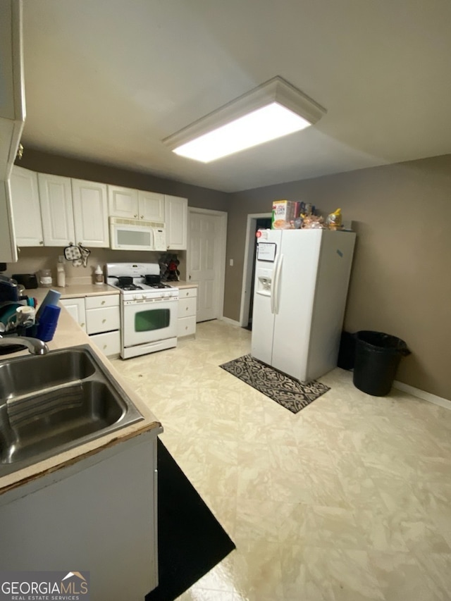 kitchen featuring sink, white appliances, and white cabinets