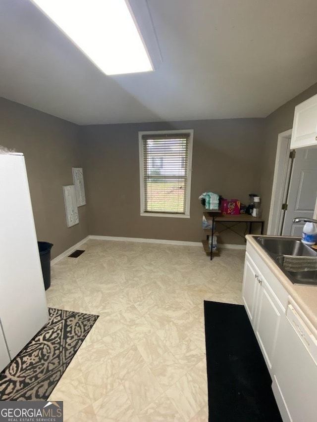 215 Sims St, Palmetto, GA 30268 - kitchen featuring white cabinetry, baseboards, and a sink