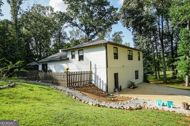 back of house featuring a lawn and a patio area