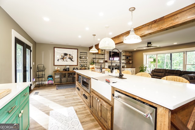 kitchen featuring hanging light fixtures, appliances with stainless steel finishes, light hardwood / wood-style floors, ceiling fan, and a kitchen island