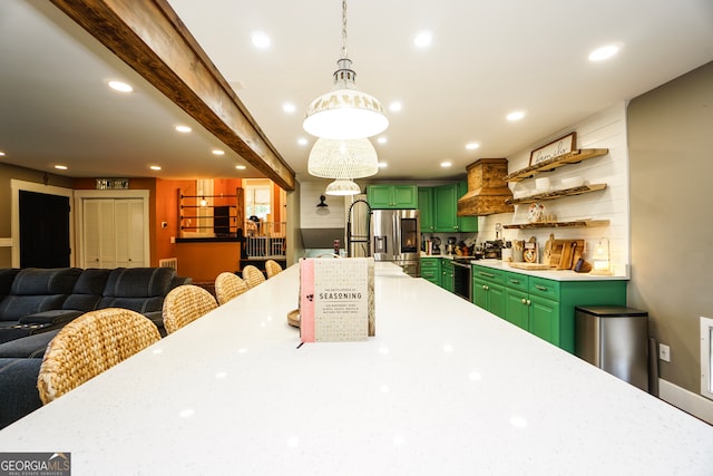 kitchen with appliances with stainless steel finishes, beamed ceiling, green cabinetry, and pendant lighting