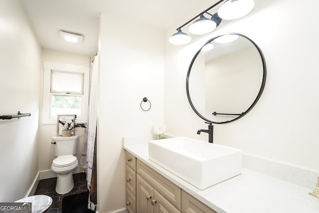 bathroom featuring tile patterned flooring, vanity, and toilet