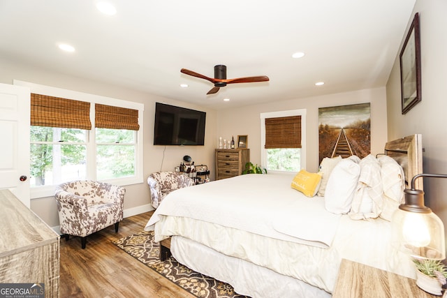 bedroom featuring multiple windows, wood-type flooring, and ceiling fan