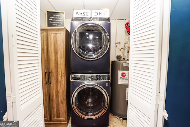 laundry area featuring stacked washing maching and dryer, cabinets, and water heater