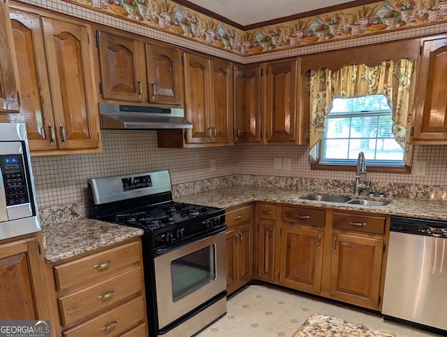 kitchen with light stone counters, stainless steel appliances, decorative backsplash, and sink