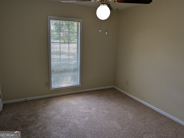 empty room featuring ceiling fan and carpet