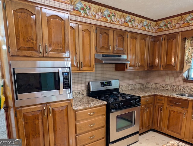 kitchen with backsplash, stainless steel appliances, and light stone countertops